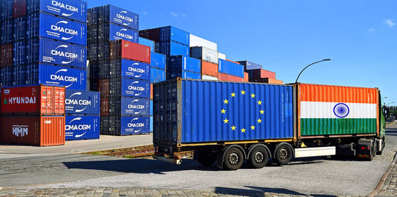 Rekka kuljettaa kahta konttia, joista ensimmäiseen on kuvattu Euroopan unionin lippu ja jälkimmäiseen Intian lippu.