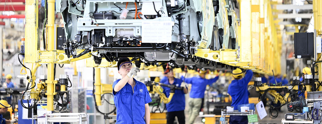 Työntekijät kokoavan henkilöautoa Kiinalaisessa autotehtaassa.