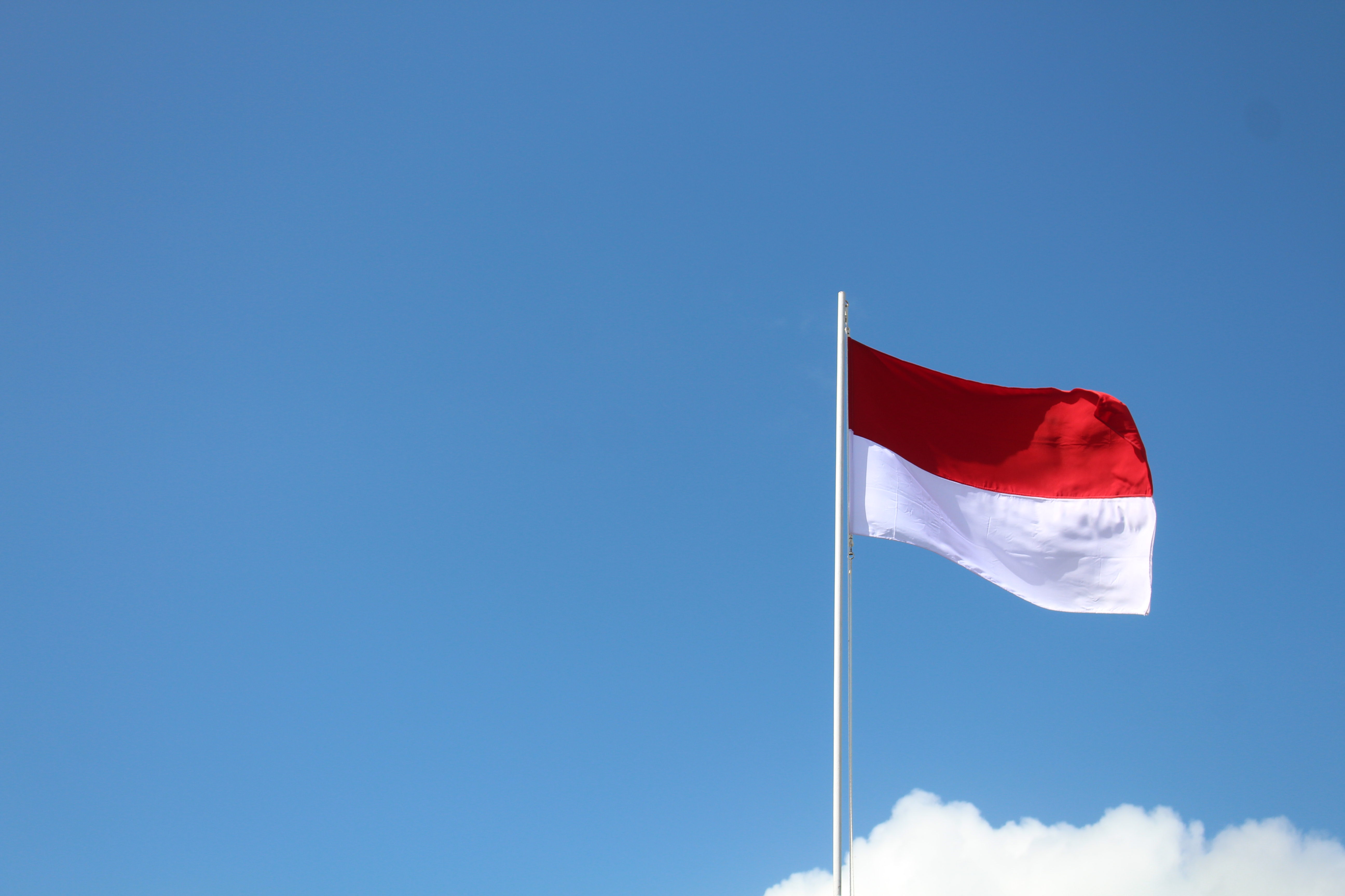 Indonesian lippu salossa vasten sinistä taivasta.